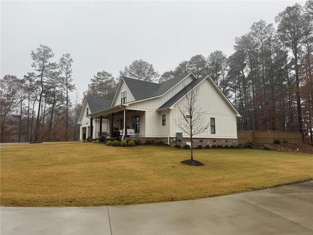 view of property exterior with a yard, covered porch, and a garage