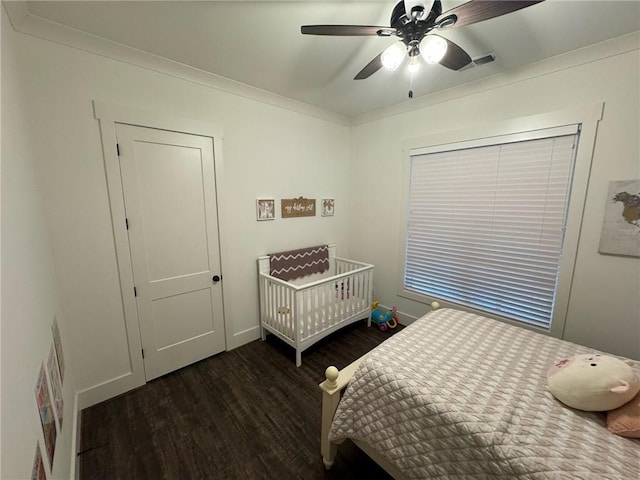 bedroom featuring dark hardwood / wood-style floors, ceiling fan, and ornamental molding