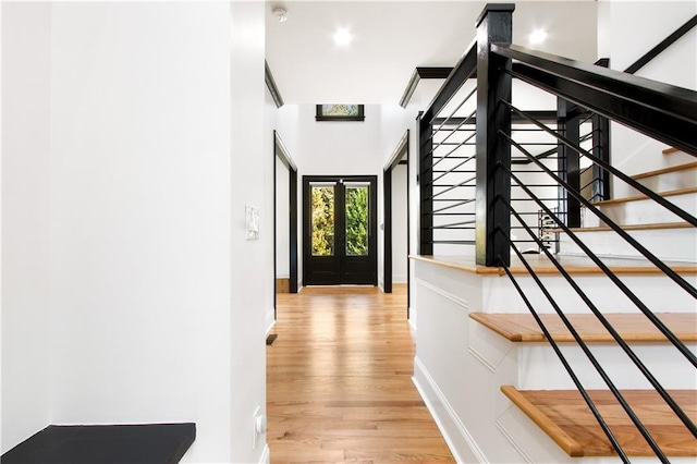 hall with light wood-type flooring and french doors