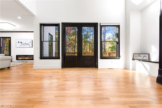 entryway featuring light wood-type flooring, french doors, and a wealth of natural light