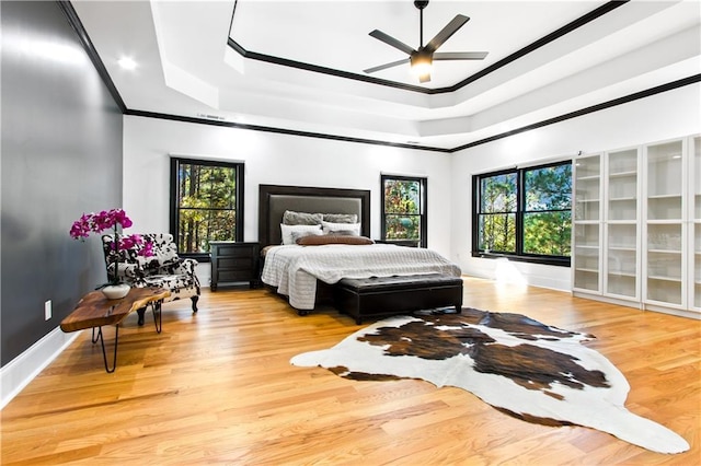 bedroom featuring multiple windows, crown molding, and light hardwood / wood-style flooring