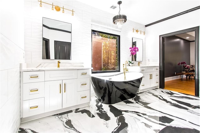 bathroom featuring tile walls, vanity, a chandelier, and a bathtub