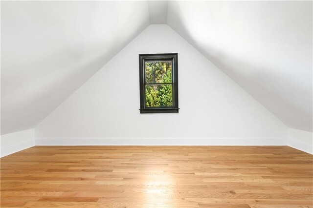 additional living space with lofted ceiling and light hardwood / wood-style floors