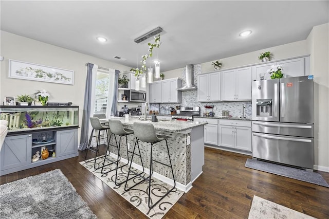 450 Noblewood Dr, Mcdonough, GA 30252 - kitchen with stainless steel appliances, wall chimney range hood, a kitchen breakfast bar, white cabinets, and dark wood-style flooring