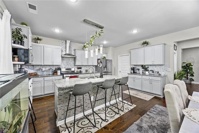 450 Noblewood Dr, Mcdonough, GA 30252 - kitchen featuring appliances with stainless steel finishes, wall chimney exhaust hood, tasteful backsplash, a kitchen bar, and white cabinets