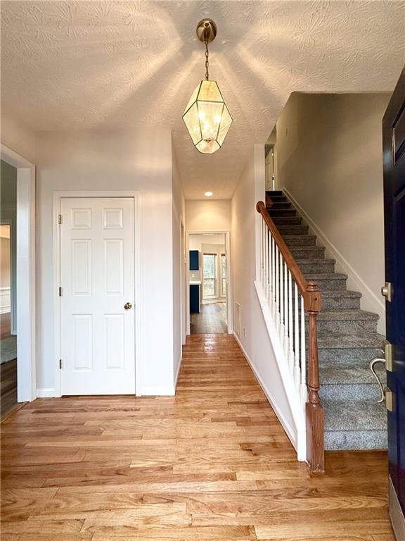 entrance foyer with a textured ceiling and light wood-type flooring