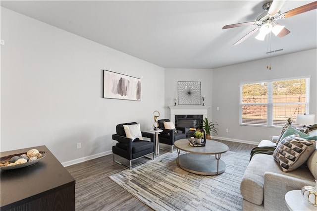 living room with dark hardwood / wood-style flooring and ceiling fan