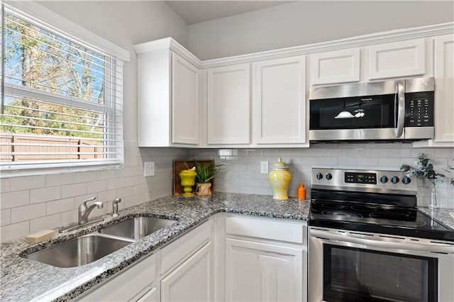 kitchen with backsplash, sink, white cabinetry, and stainless steel appliances