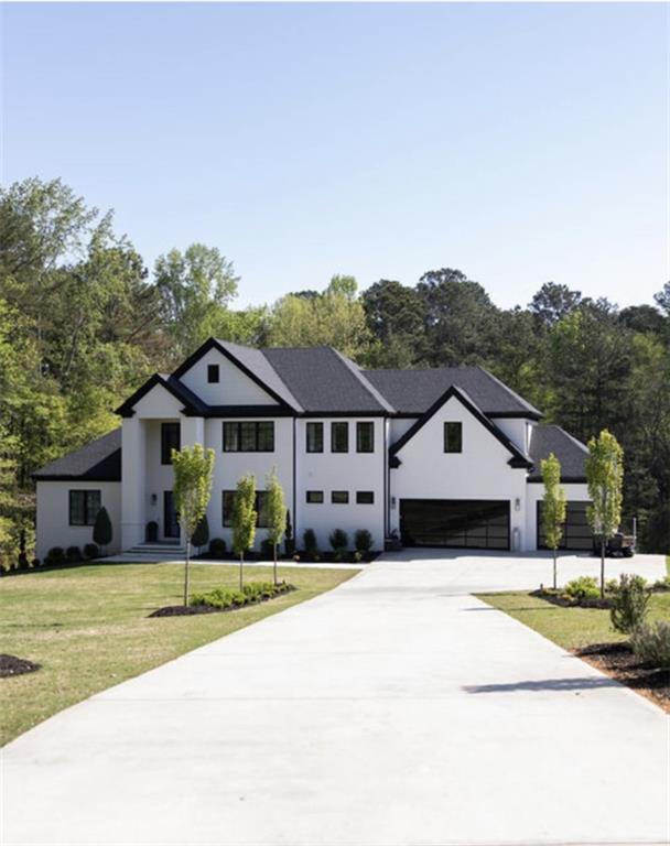 view of front of house featuring an attached garage, driveway, and a front yard