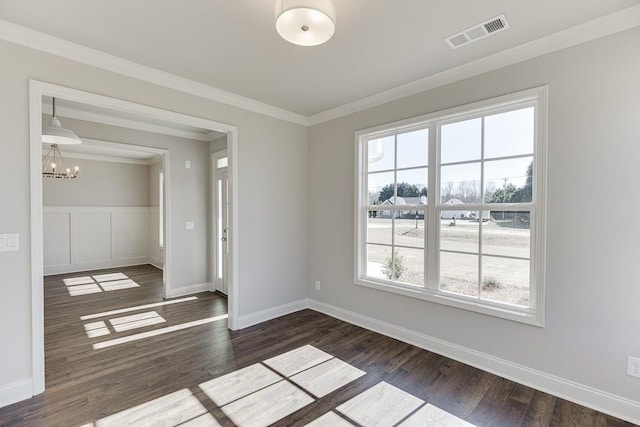 unfurnished room with visible vents, a notable chandelier, dark wood finished floors, and crown molding