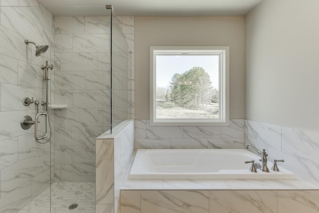 bathroom featuring a bath and a shower stall