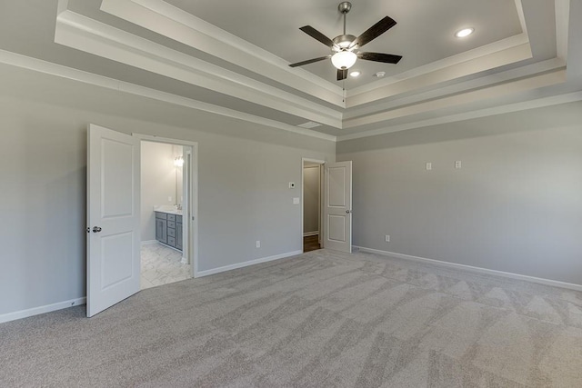 unfurnished bedroom featuring baseboards, a raised ceiling, and light carpet