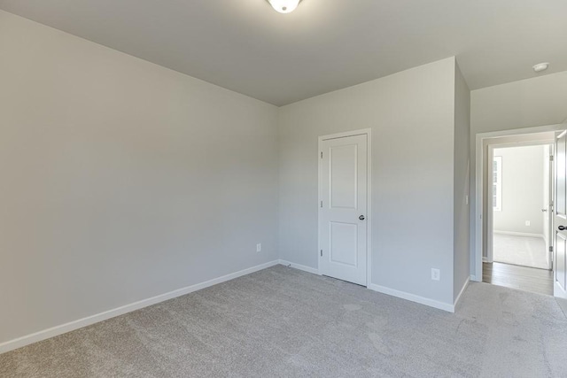 unfurnished bedroom featuring light colored carpet and baseboards