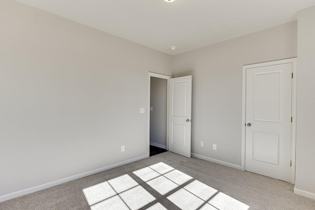 unfurnished bedroom with baseboards and light colored carpet