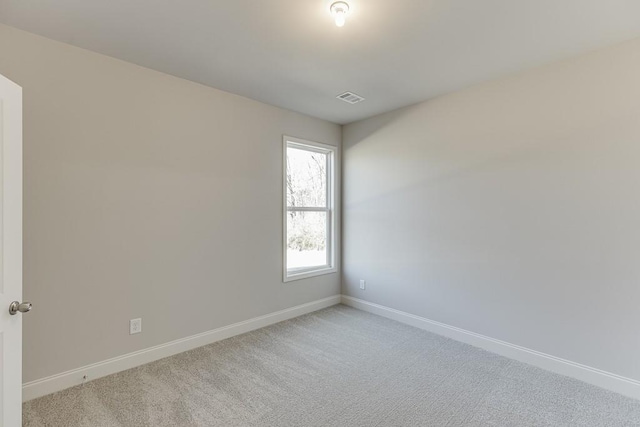 unfurnished room with baseboards, visible vents, and light carpet