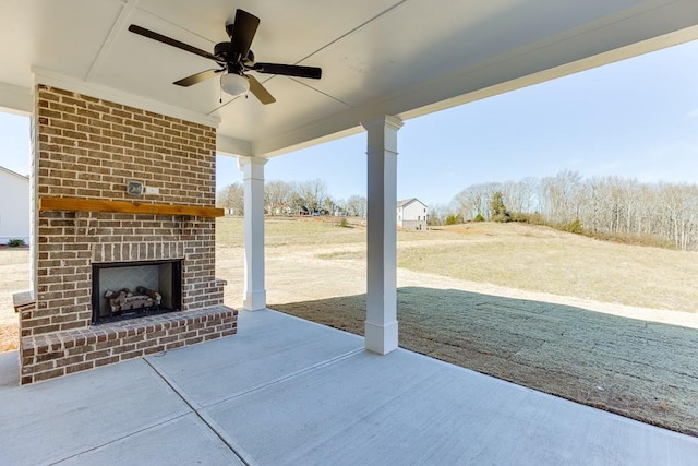 view of patio featuring a ceiling fan and an outdoor brick fireplace