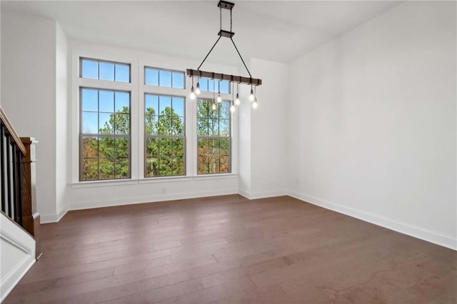 unfurnished dining area with dark wood-type flooring