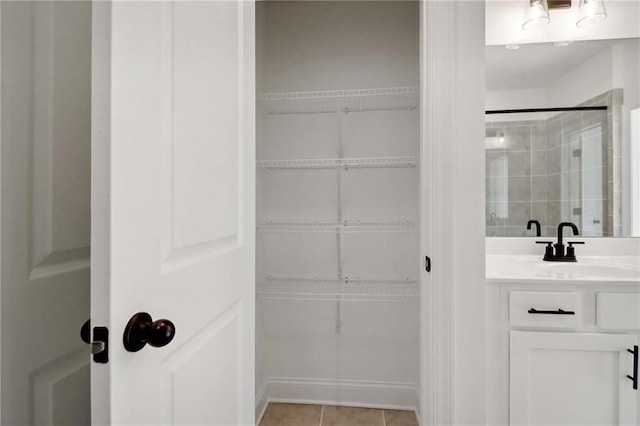 interior space with tile patterned floors, an enclosed shower, and vanity