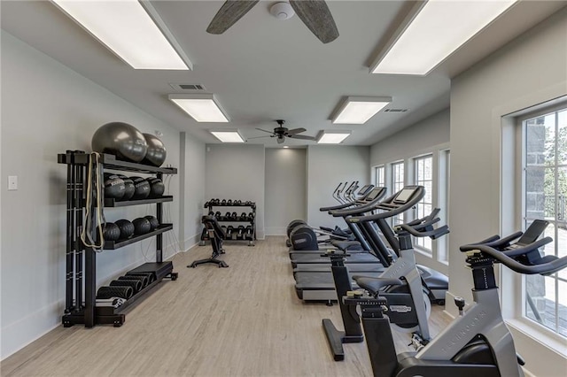 workout area with light hardwood / wood-style flooring and ceiling fan