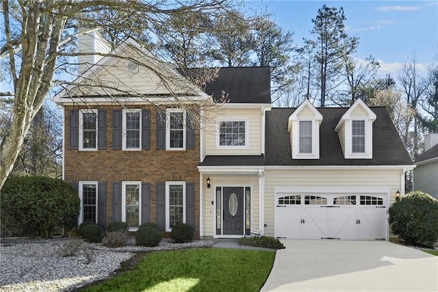 view of front facade with a garage, concrete driveway, and a shingled roof