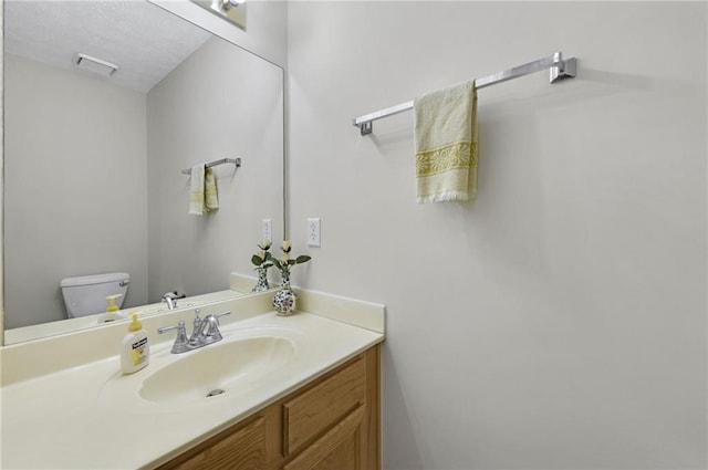 bathroom with toilet, visible vents, a textured ceiling, and vanity