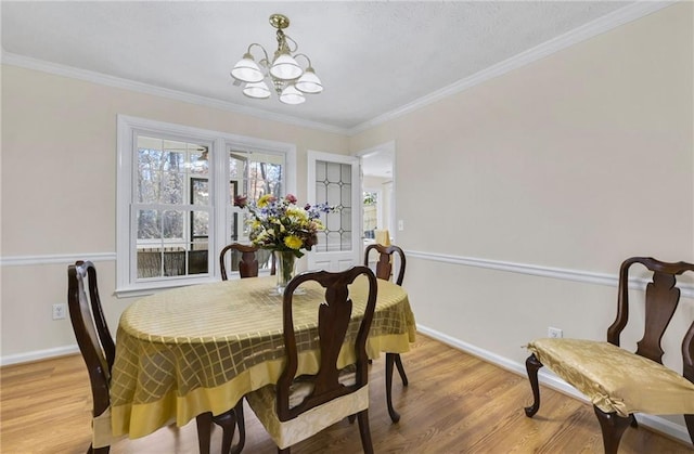 dining space featuring light wood-style flooring, ornamental molding, and baseboards