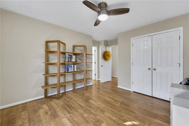 unfurnished bedroom featuring a closet, baseboards, and light wood finished floors