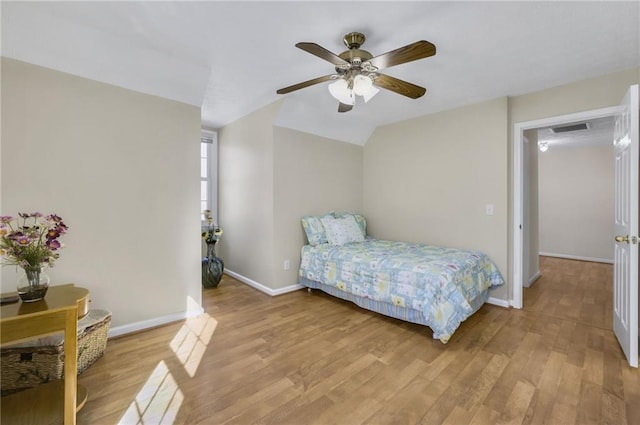 bedroom featuring baseboards, visible vents, a ceiling fan, vaulted ceiling, and light wood-type flooring