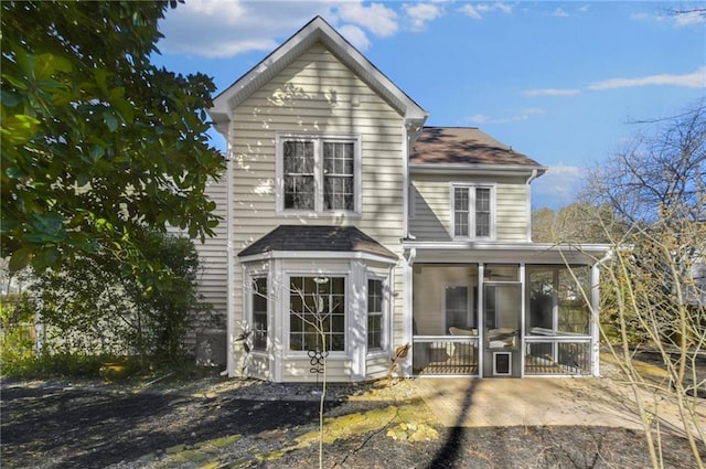 rear view of house featuring a sunroom