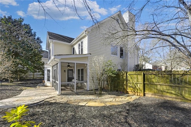 view of property exterior featuring a sunroom, fence, and ceiling fan