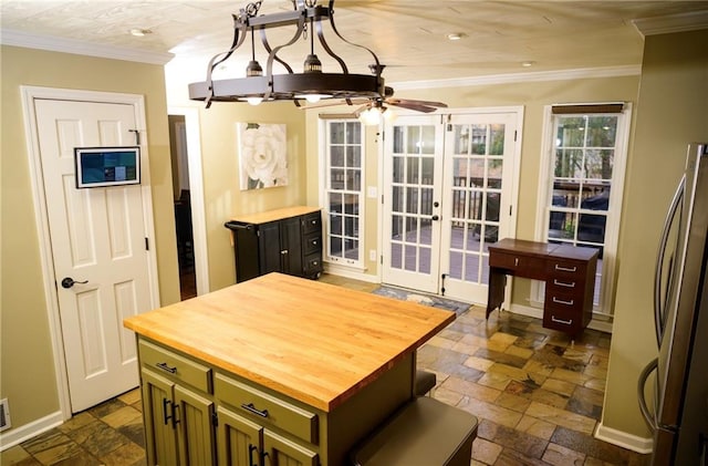 kitchen featuring stainless steel fridge, ornamental molding, green cabinets, ceiling fan, and french doors