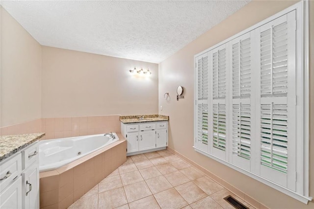 2140 Old Orchard Ln, Canton, GA 30114 - full bath featuring vanity, a tub with jets, a textured ceiling, and tile patterned flooring