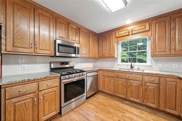 2140 Old Orchard Ln, Canton, GA 30114 - kitchen featuring stainless steel appliances, brown cabinets, light stone counters, and a textured ceiling