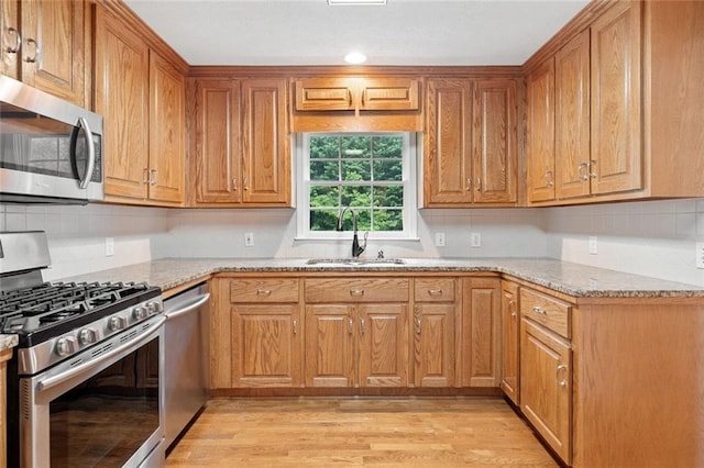 2140 Old Orchard Ln, Canton, GA 30114 - kitchen featuring stainless steel appliances, light stone countertops, light wood-style floors, tasteful backsplash, and brown cabinetry