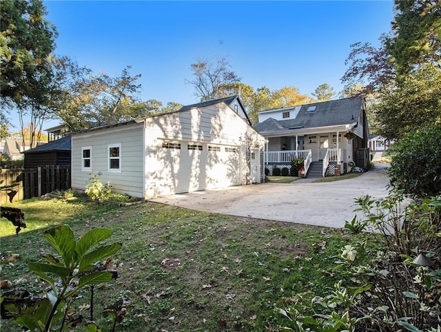 rear view of property with a yard, a porch, fence, and driveway