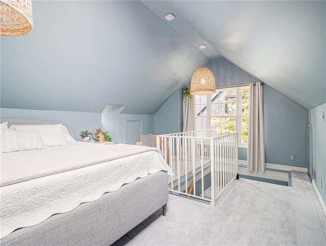 carpeted bedroom with lofted ceiling and baseboards