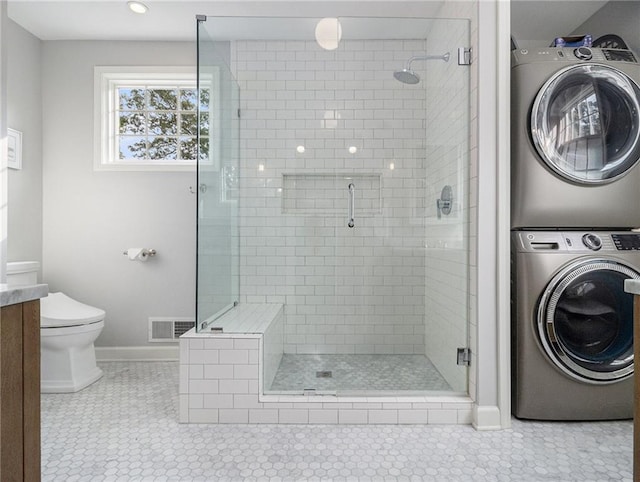 full bath with stacked washer and dryer, a stall shower, visible vents, toilet, and vanity