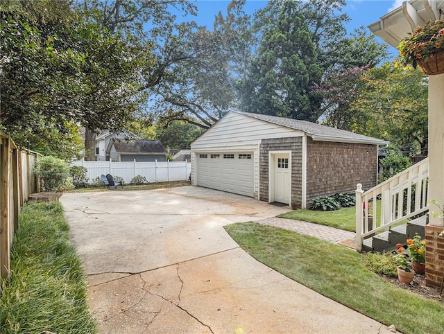 detached garage featuring fence