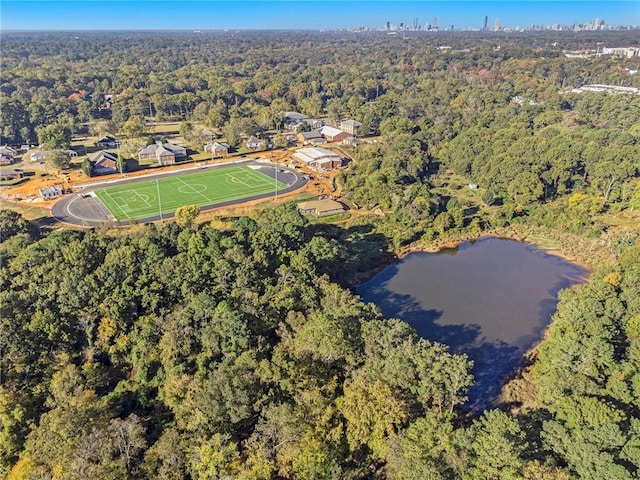 birds eye view of property featuring a water view and a wooded view