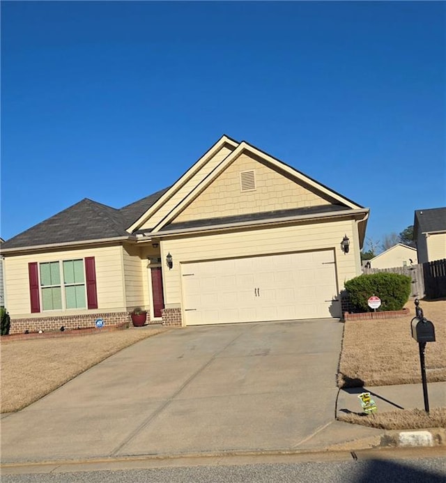 view of front of home with fence, brick siding, a garage, and driveway