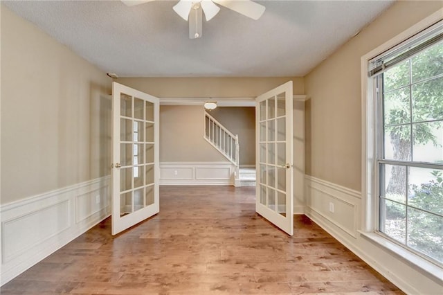 12060 Carriage Park Ln, Duluth, GA 30097 - spare room featuring french doors, healthy amount of natural light, a decorative wall, a wainscoted wall, and ceiling fan