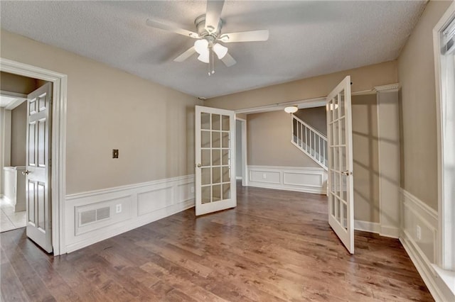 12060 Carriage Park Ln, Duluth, GA 30097 - unfurnished room with french doors, a ceiling fan, a textured ceiling, wood finished floors, and a decorative wall