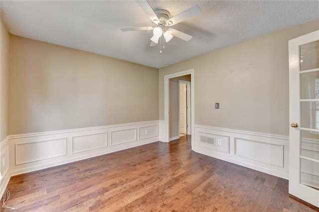 12060 Carriage Park Ln, Duluth, GA 30097 - unfurnished room with a ceiling fan, a wainscoted wall, and wood finished floors