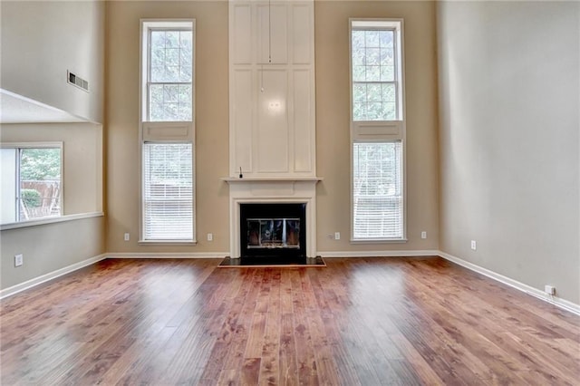 12060 Carriage Park Ln, Duluth, GA 30097 - unfurnished living room featuring wood finished floors, a fireplace, baseboards, and a towering ceiling