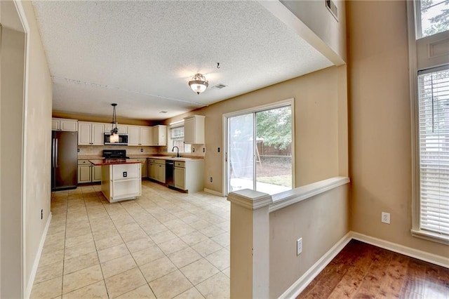 12060 Carriage Park Ln, Duluth, GA 30097 - kitchen with appliances with stainless steel finishes, a sink, a textured ceiling, baseboards, and a kitchen island