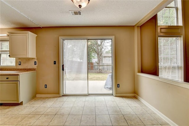 12060 Carriage Park Ln, Duluth, GA 30097 - unfurnished dining area with a textured ceiling, light tile patterned floors, and baseboards