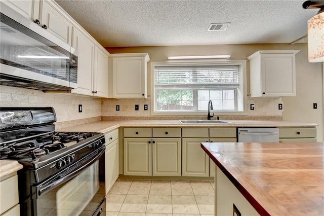 12060 Carriage Park Ln, Duluth, GA 30097 - kitchen with appliances with stainless steel finishes, butcher block counters, a sink, backsplash, and a textured ceiling