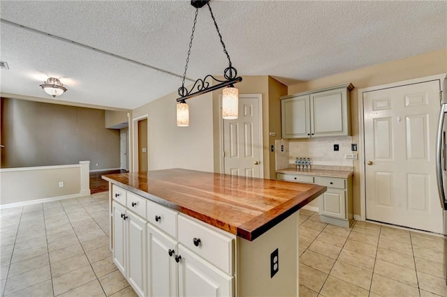 12060 Carriage Park Ln, Duluth, GA 30097 - kitchen with light tile patterned flooring, wooden counters, a textured ceiling, a kitchen island, and decorative light fixtures