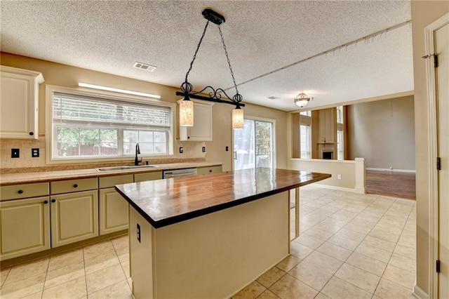 12060 Carriage Park Ln, Duluth, GA 30097 - kitchen featuring a sink, decorative backsplash, light tile patterned floors, a textured ceiling, and decorative light fixtures