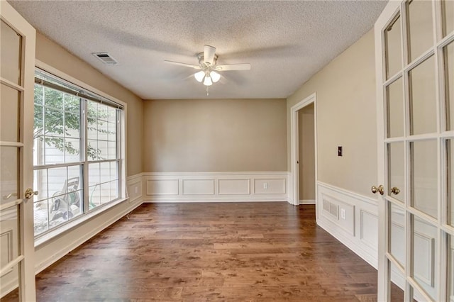 12060 Carriage Park Ln, Duluth, GA 30097 - empty room featuring a ceiling fan, wood finished floors, a textured ceiling, and a wainscoted wall